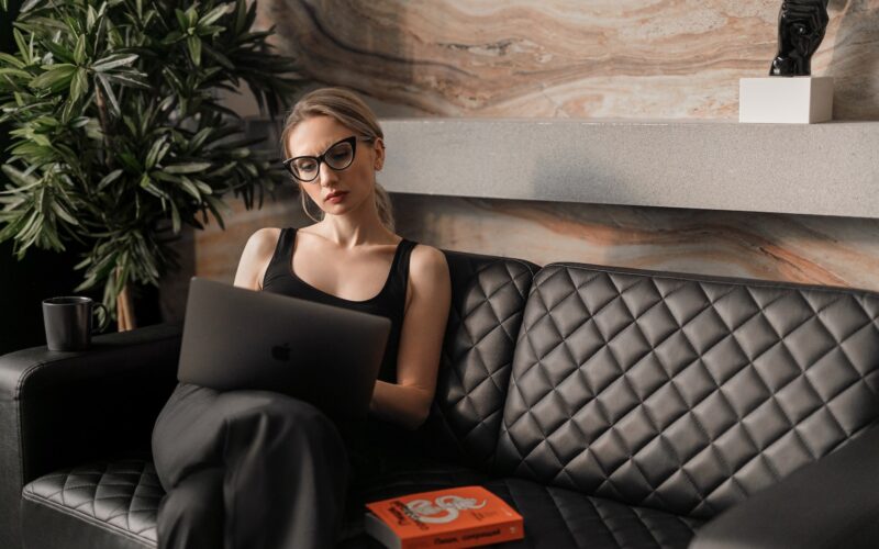 woman in black tank top wearing sunglasses sitting on black leather couch