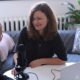 woman in black half-sleeved shirt sitting while facing woman and smiling